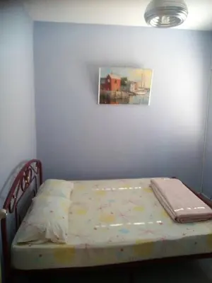 a bed in a bedroom with a painting on the wall at Batu Kawan HS in Simpang Ampat