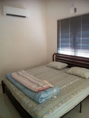 two twin beds in a room with a window at Batu Kawan HS in Simpang Ampat
