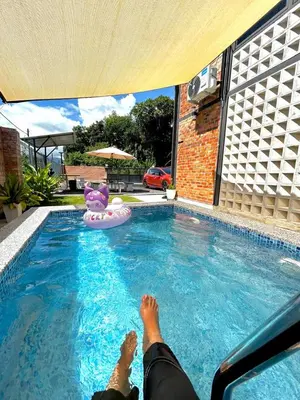 a person laying on a raft in a swimming pool at Kurie Redbrick House in Balik Pulau