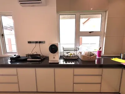 a kitchen with a black counter top and two windows at Heartstay Tanjong Karang \u598d\u83c1\u540d\u5bbf in Kampong Tanjong Karang