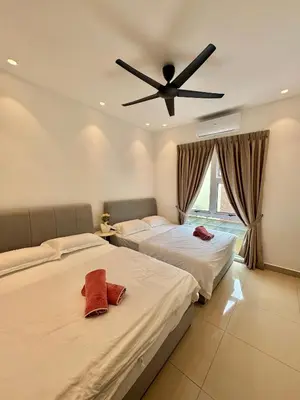 two beds in a bedroom with a ceiling fan at Heartstay Tanjong Karang \u598d\u83c1\u540d\u5bbf in Kampong Tanjong Karang