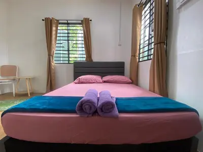 a bed with two towels on top of it at Roomstay Cikgu Mie in Bayan Lepas