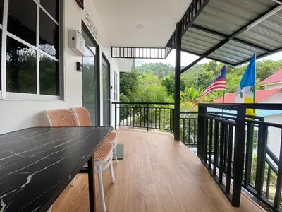 a room with a balcony with a table and chairs at Roomstay Cikgu Mie in Bayan Lepas