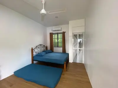 two beds in a room with a window at Roomstay Cikgu Mie in Bayan Lepas
