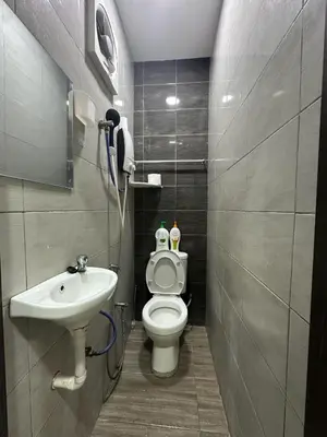 a small bathroom with a toilet and a sink at Specious Living Cozy House in Bukit Mertajam