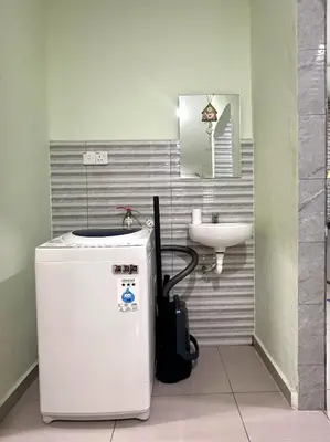 a small bathroom with a sink and a refrigerator at Specious Living Cozy House in Bukit Mertajam