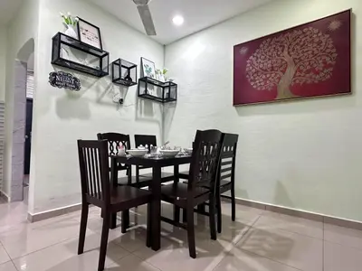 a dining room with a black table and chairs at Specious Living Cozy House in Bukit Mertajam