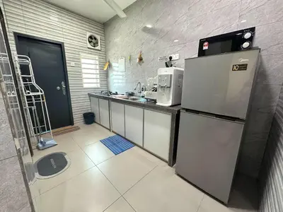 a small kitchen with a refrigerator and a sink at Specious Living Cozy House in Bukit Mertajam