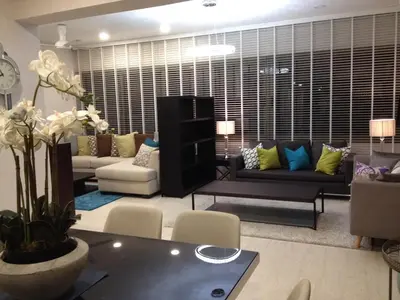 a living room with a couch and a table at By the Sea PENTHOUSE duplex in Batu Ferringhi
