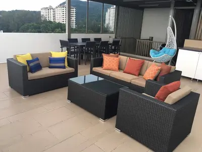a room with two couches with colorful pillows at By the Sea PENTHOUSE duplex in Batu Ferringhi