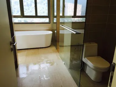 a bathroom with a tub and a toilet and a window at By the Sea PENTHOUSE duplex in Batu Ferringhi