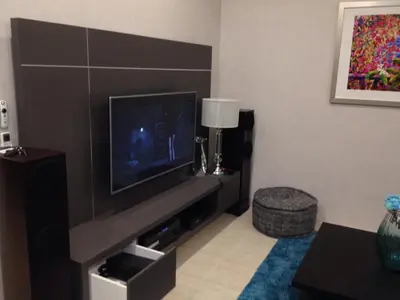 a living room with a flat screen tv on a wall at By the Sea PENTHOUSE duplex in Batu Ferringhi