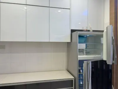 a kitchen with white cabinets and an empty refrigerator at Seri Hayzar Homestay in Gua Sai