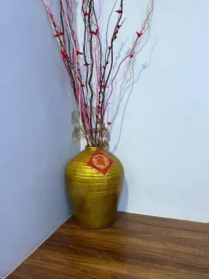 a yellow vase with branches in it sitting on a table at Seri Hayzar Homestay in Gua Sai