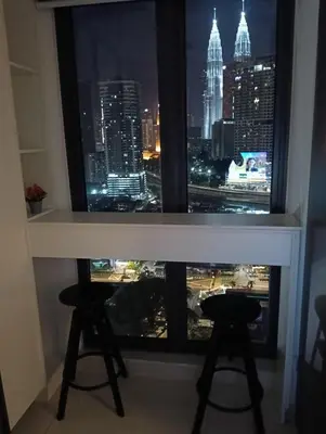 a window with two stools in a room with a city skyline at Infinitum suites at colony KLCC in Gua Sai