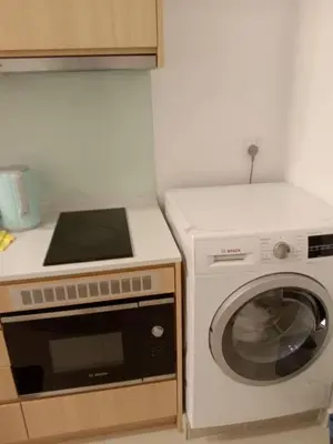 a kitchen with a stove and a washing machine at Infinitum suites at colony KLCC in Gua Sai