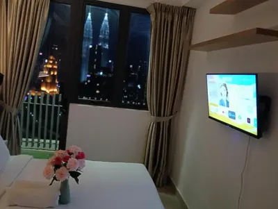 a room with a tv and a bed and a window at Infinitum suites at colony KLCC in Gua Sai