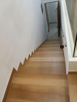 a staircase in a house with wooden floors and white walls at Infinitum suites at colony KLCC in Gua Sai