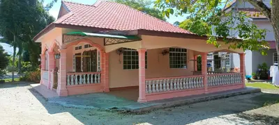 a small pink house with a red roof at ASTANA INN HOMESTAY Balik Pulau in Balik Pulau