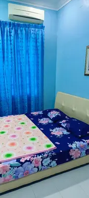 a bedroom with a bed with a blue curtain at ASTANA INN HOMESTAY Balik Pulau in Balik Pulau