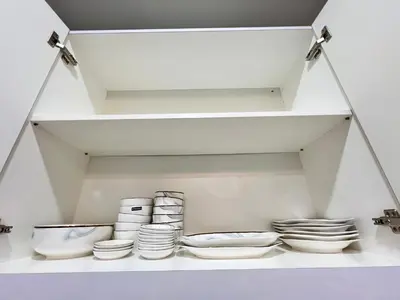 a white shelf with bowls and plates on it at Love Mickey Cameron Highlands in Cameron Highlands