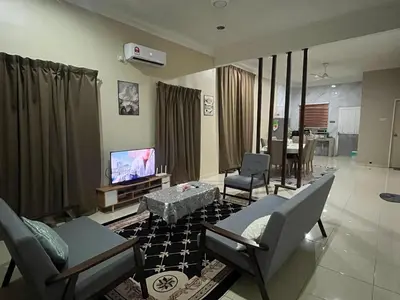 a living room with a couch and a tv in it at Ummu Homestay 03 in Batu Gajah
