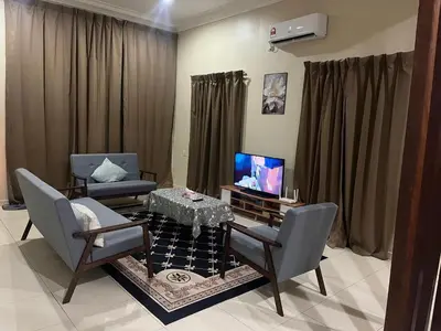 a living room with a table and chairs and a television at Ummu Homestay 03 in Batu Gajah
