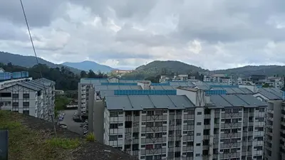 a group of apartment buildings with mountains in the background at Golden Bright Future Trading in Tanah Rata