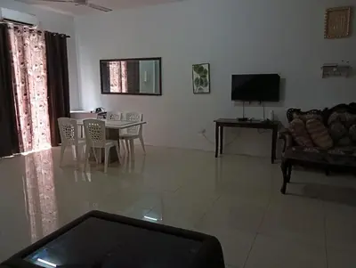a living room with a couch and a table with chairs at Taman yu sungai besar in Sungai Besar