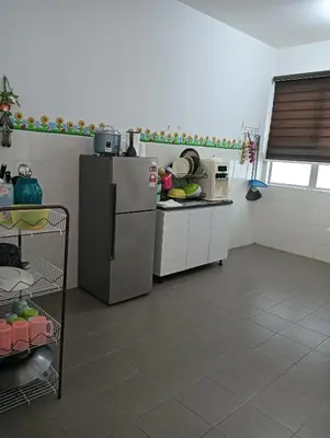 a kitchen with a refrigerator and a counter at Taman yu sungai besar in Sungai Besar