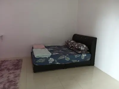 a small bed in a corner of a room at Taman yu sungai besar in Sungai Besar