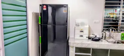 a black refrigerator in a kitchen next to a counter at 18pax Bungalow Homestay Hutan Melintang in Hutan Melintang