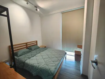 a bedroom with a bed and a sliding glass door at Cozy City Stay at Kuching Prime location in Gua Sai