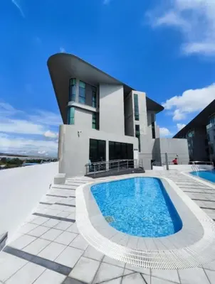 a building with a swimming pool in front of a building at Cozy City Stay at Kuching Prime location in Gua Sai