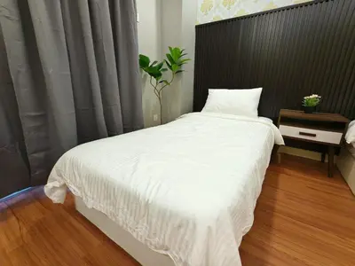 a bedroom with a large white bed with a black headboard at JJ's Modern Suite Kampar- Near UTAR in Kampar