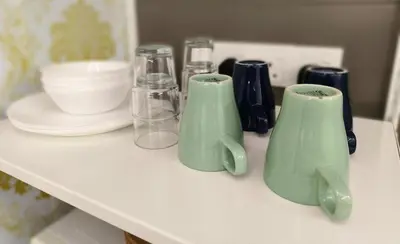 a shelf with two green vases on a table at JJ's Modern Suite Kampar- Near UTAR in Kampar