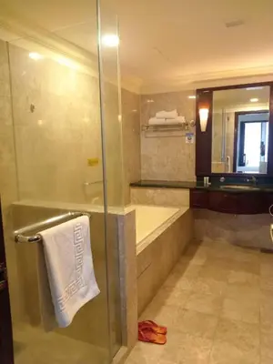 a bathroom with a shower and a tub and a towel at Kuala Lumpur Residence At Hotel Times square in Gua Sai