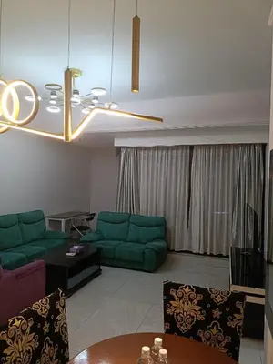 a living room with green couches and a table at Kuala Lumpur Residence At Hotel Times square in Gua Sai