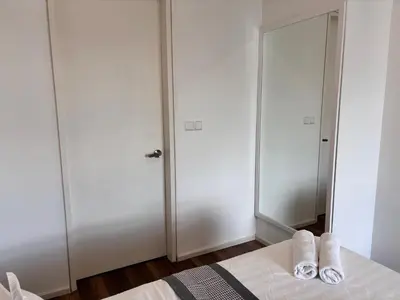 a bedroom with two closets and a bed with slippers at Theme Park Ipoh - Onsen Premier Suites By LUX SUITE in Ipoh