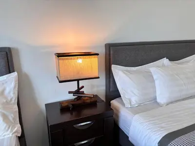 a lamp on a night stand next to a bed at Theme Park Ipoh - Onsen Premier Suites By LUX SUITE in Ipoh