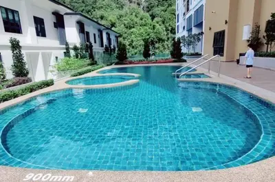 a swimming pool with blue water in a building at Theme Park Ipoh - Onsen Premier Suites By LUX SUITE in Ipoh