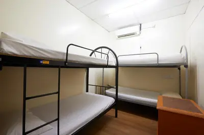 two bunk beds in a room with a desk at Ros Heritage Motel in George Town