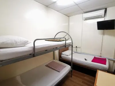 a small room with two bunk beds and a tv at Ros Heritage Motel in George Town