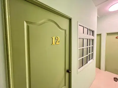 a green door with the number on it at KISABEL Budget Hotel in Tanah Rata