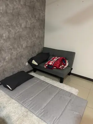 a bed sitting in a room with a couch at home sweet home in Kampong Batu Maung