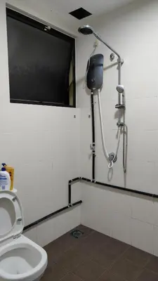 a bathroom with a toilet and a television on the wall at home sweet home in Kampong Batu Maung