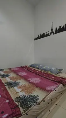 a bed with a blanket on top of a wall at home sweet home in Kampong Batu Maung