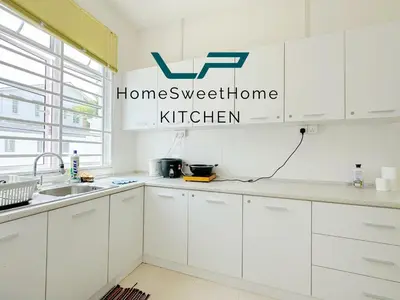 a kitchen with white cabinets and a sign that reads home sweet home kitchen at Penang Balik Pulau BBQ & KARAOKE Home in Balik Pulau