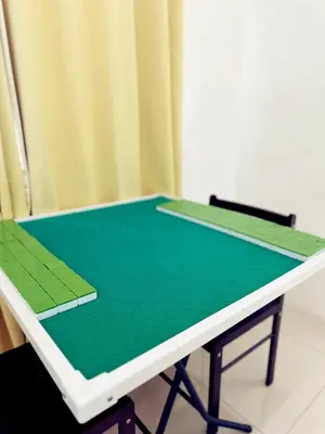 a ping pong table with a green ping pong racket at Penang Balik Pulau BBQ & KARAOKE Home in Balik Pulau