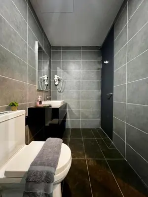 a bathroom with a toilet and a sink and a tub at Sunway Onsen Ipoh by EUcation Home in Tambun